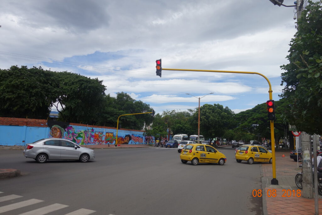 Intersección en Cúcuta con semáforos LED solares instalados por Smart Planning y taxis circulando.