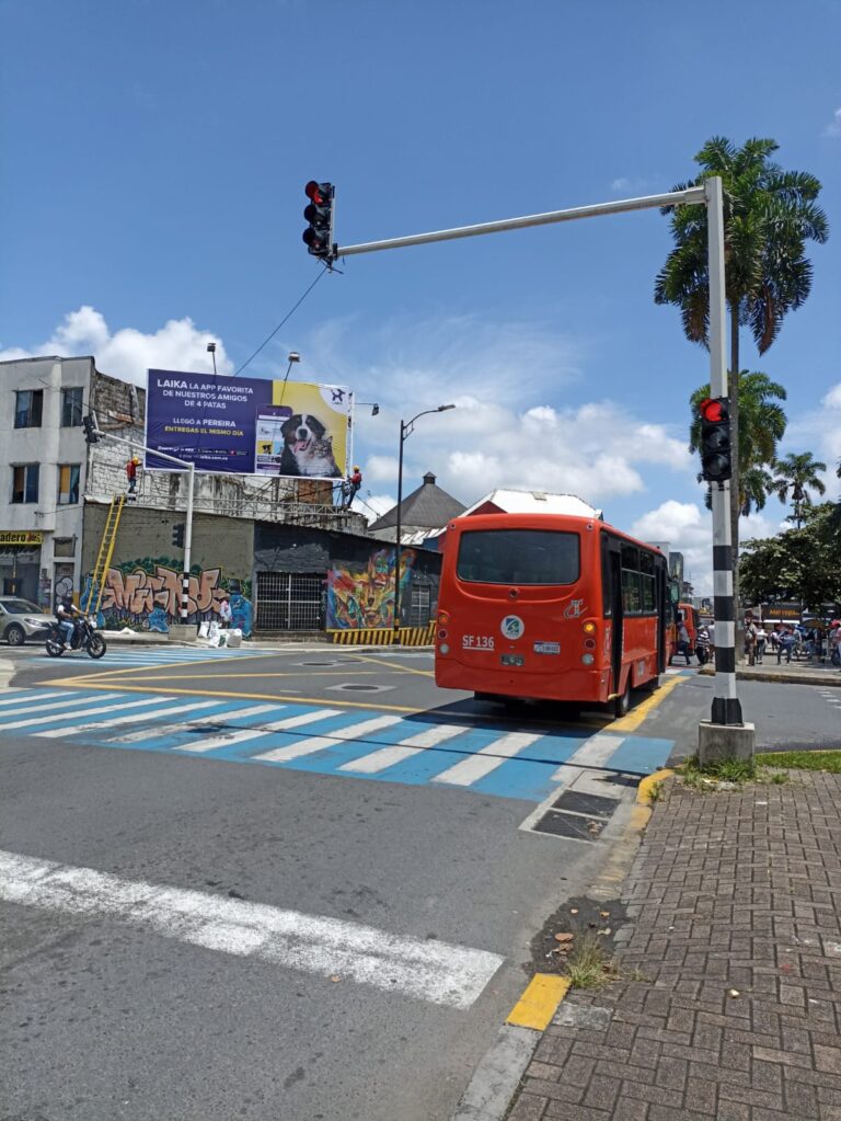 Operario con casco y guantes inserta estoperoles metálicos y acomoda cables dentro de cámara subterránea en calle de Pereira.