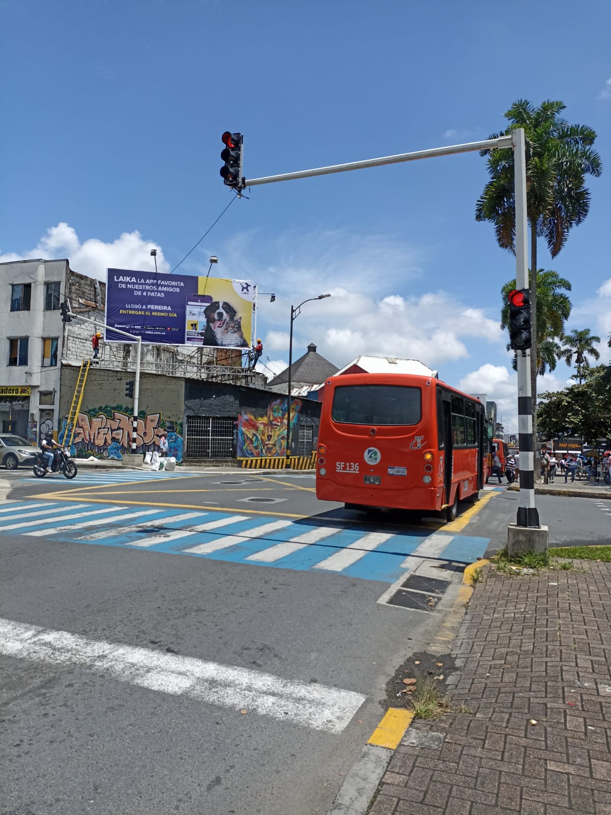 Operario con casco y guantes inserta estoperoles metálicos y acomoda cables dentro de cámara subterránea en calle de Pereira.
