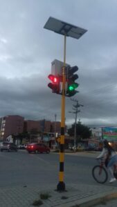 Semáforo con luz verde y roja, alimentado por módulo solar, instalado en intersección de Madrid.