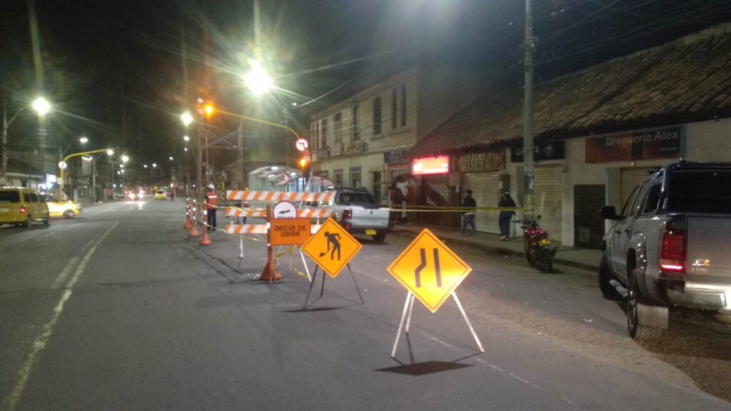 Obreros de Smart Planning sitúan barreras y conos con señales “Inicio de obra” en intersección de Madrid de noche.