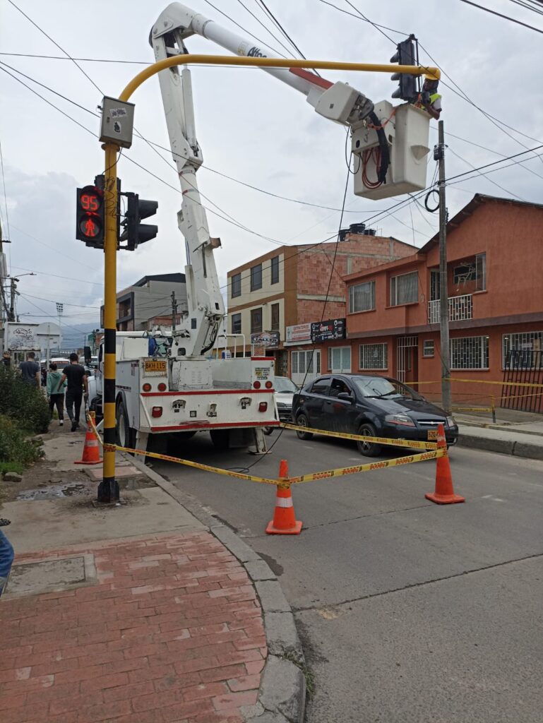 Técnico de Smart Planning en canastilla ajusta semáforos y módulo de control inteligente alimentado por energía solar en Chía.