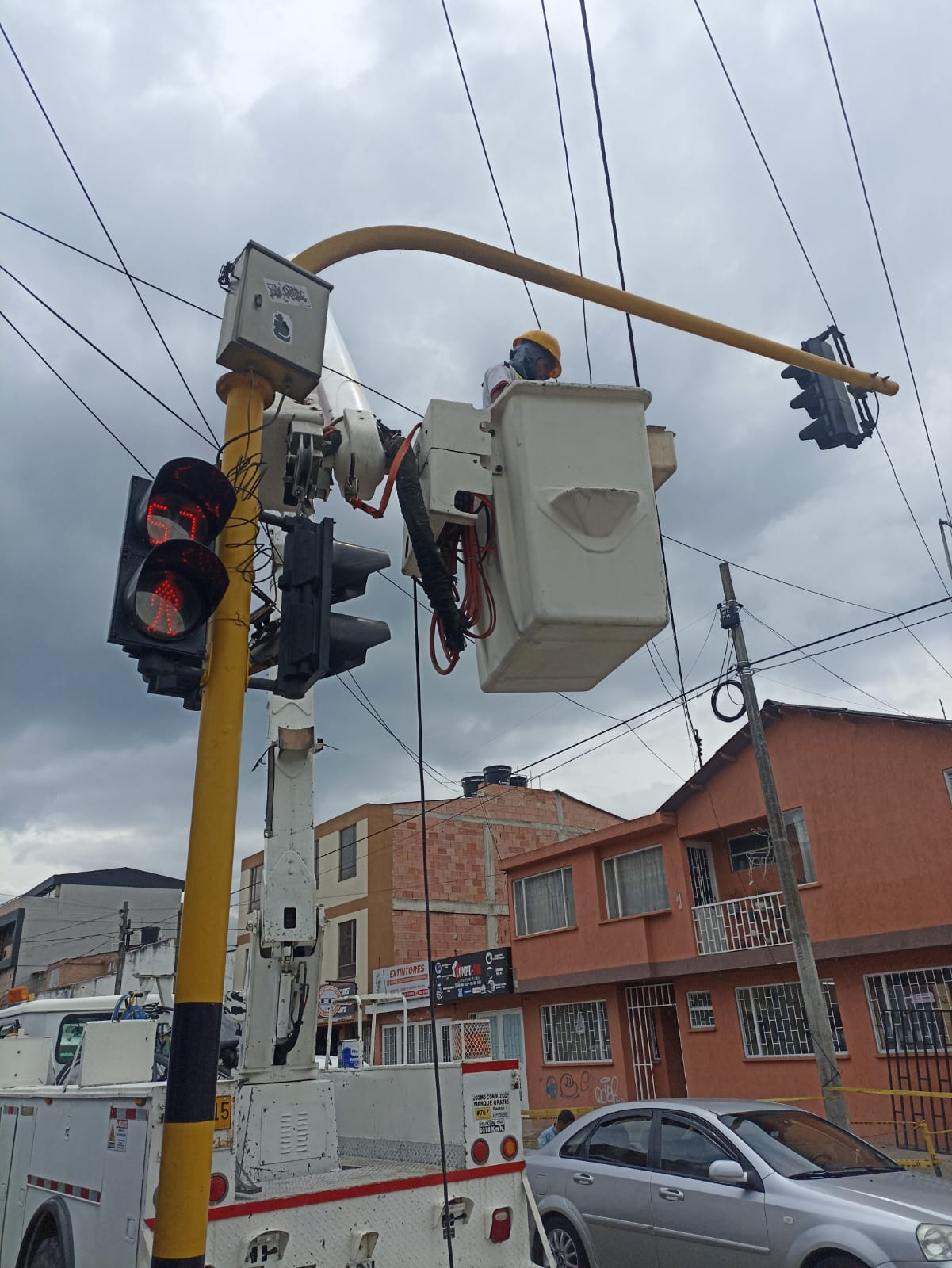Camión canastilla de Smart Planning con técnico realizando mantenimiento de semáforos en intersección urbana de Chía, con conos de seguridad para el mantenimiento de Semaforos.