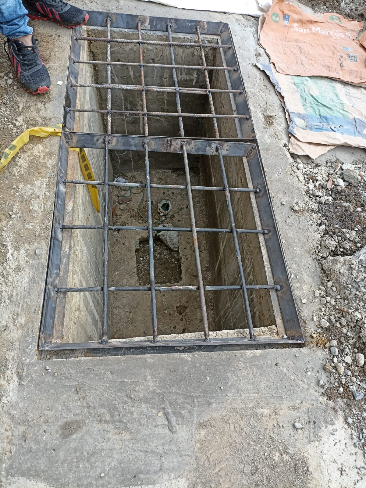 Rejilla y marco de acero instalados sobre cámara de paso de cables semafóricos durante obras civiles en Santiago de Cali.