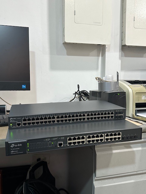 Dos switches de red apilados sobre mesa en almacén, listos para integrarse con UPS en la Seccional de Ibagué.