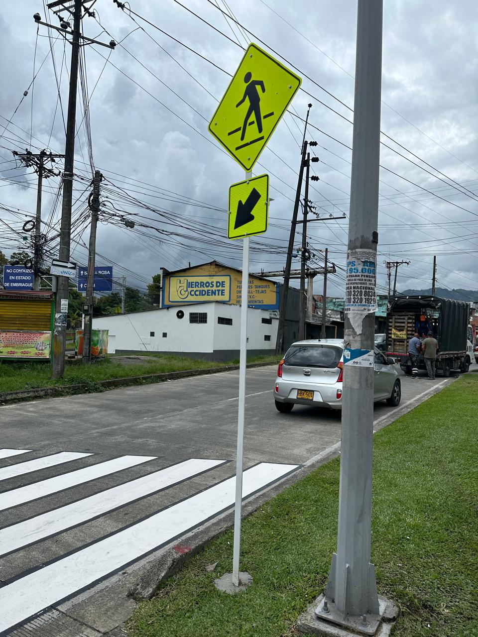 Señal peatonal reflectiva amarilla montada por Smart Planning en Dosquebradas, junto a paso de cebra