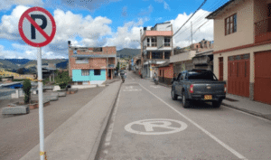 Señal de prohibido parquear instalada en vía urbana de Nariño, acompañada de demarcación horizontal en el pavimento.